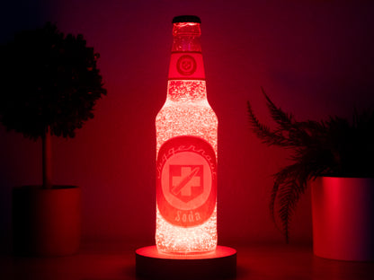 The Juggernog Perk a Cola Bottle Light by Bottle Light Company glows bright red on a circular LED base, surrounded by two potted plants against a dark background. Inspired by the classic Call of Duty Zombies Juggernog Perk-a-Cola.