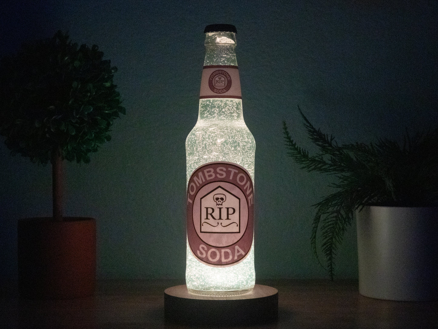 The Bottle Light Companys Tombstone Perk a Cola Bottle Light features a glowing Tombstone Soda label with RIP on a tombstone graphic, surrounded by plants—a must-have Call of Duty Zombies collectible.
