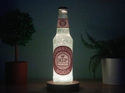 The Bottle Light Companys Tombstone Perk a Cola Bottle Light features a glowing Tombstone Soda label with RIP on a tombstone graphic, surrounded by plants—a must-have Call of Duty Zombies collectible.